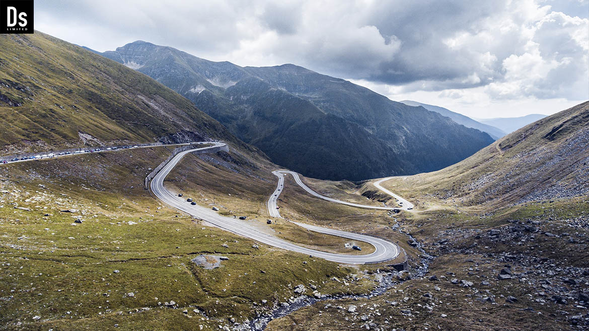 At the summit of the Transfagarasan Highway, amidst the majestic mountains, Denys Dynamics paused to savor a cup of freshly brewed coffee. Sitting on the edge of a cliff, he slowly lifted the mug to his lips, the warm aroma enveloping his senses like a comforting embrace.  With each sip, he felt his heart fill with tranquility, the worries and hustle of everyday life fading into the background. His gaze drifted along the winding road that snaked down through lush hills and rocky outcrops, resembling a silver ribbon stretching into infinity.  The road seemed crafted for this moment, leading to new discoveries and adventures. He observed a light mist wrapping around the mountain peaks, and with each passing minute, the scene became increasingly enchanting. Sunbeams broke through the clouds, illuminating the vibrant colors of nature, imbuing everything around him with an air of magic.  In that moment, immersed in silence and serenity, Denys realized that such moments were the essence of life. He was not in a hurry; he simply existed in that space and time, relishing the gifts the world offered him in this place. With every sip of coffee, he felt the energy of nature infuse him, filling him with renewed strength and inspiration for future journeys.